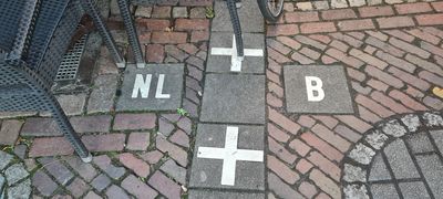 White crosses mark the international border of Baarle. On the left, we see the Netherlands, and on the right, it’s Belgium. 